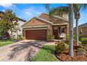 Beautiful home with a brick driveway, lush greenery, a two-car garage and stone facade at 11656 Lake Blvd, New Port Richey, FL 34655