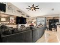 Cozy living room featuring a rustic wood accent wall, ceiling fan, and comfortable seating area at 13416 Algoma Ave, Spring Hill, FL 34609