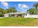 Charming single-story home with a manicured lawn, metal roof, fenced yard and an attached garage at 1414 Sunset Ln, Lutz, FL 33549