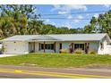 Charming one-story home with a manicured lawn, metal roof, shutters and a two-car garage at 1414 Sunset Ln, Lutz, FL 33549
