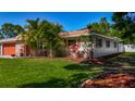 Home exterior showcasing lush lawn and mature trees at 1469 S Hillcrest Ave, Clearwater, FL 33756
