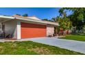 Home featuring a stone facade and an orange garage door at 1469 S Hillcrest Ave, Clearwater, FL 33756