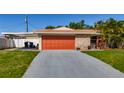Single story home featuring an orange garage door and a stone facade at 1469 S Hillcrest Ave, Clearwater, FL 33756