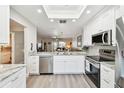 Open-concept kitchen showcasing white cabinets, stainless steel appliances, and seamless flow to the living areas at 1535 Nursery Rd # 111, Clearwater, FL 33756