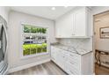 Well-lit kitchen featuring white cabinets, stone countertops, and modern appliances at 1535 Nursery Rd # 111, Clearwater, FL 33756
