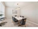 Elegant dining room featuring a modern chandelier and a sleek, white table with seating for six at 16709 Barnwood Pl, Bradenton, FL 34211