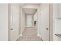 Bright hallway with tile flooring, leading to the front door, with white doors on either side at 16709 Barnwood Pl, Bradenton, FL 34211