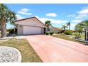 Inviting single-story home with a two-car garage, desert landscaping, and a red-colored driveway at 1969 Wolf Laurel Dr, Sun City Center, FL 33573