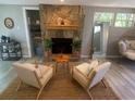 Charming stone fireplace with a wooden mantle, surrounded by comfortable seating, creating a cozy focal point at 205 Park Ridge Ave, Temple Terrace, FL 33617