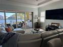 Cozy living area with view of a lake, sliding glass doors, grill, comfortable seating, and a large TV at 2217 5Th E St, Palmetto, FL 34221