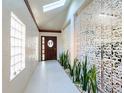 Bright entryway with skylight, decorative screen, and colorful glass details on door at 3302 W Caracas St, Tampa, FL 33614