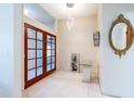 Foyer featuring double wood-framed glass doors, tile floors, modern lighting, and a mirror at 3302 W Caracas St, Tampa, FL 33614