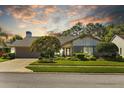 Charming single-story home with well-manicured lawn, mature landscaping, and a two-car garage at 3579 Landmark Trl, Palm Harbor, FL 34684