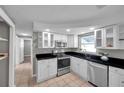 Bright kitchen with white cabinets, stainless steel appliances, and open shelving at 3624 Hendrix St, New Port Richey, FL 34652
