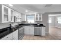 Modern kitchen with white cabinets, stainless steel appliances, and elegant black countertops at 3624 Hendrix St, New Port Richey, FL 34652