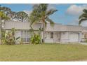 Attractive home featuring a metal roof, white siding, lush front yard, and attached one car garage and quaint porch at 3633 Richboro Dr, Holiday, FL 34691
