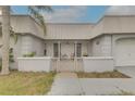 Close-up of cozy porch with seating, metal roof, privacy fence, and an inviting entrance to this charming home at 3633 Richboro Dr, Holiday, FL 34691