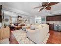 Spacious living room with a wet bar, cozy seating, decorative ceiling fans, and hardwood flooring at 4912 W Bay Way Dr, Tampa, FL 33629