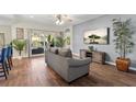 Open-concept living room with hardwood floors, access to the lanai, and a mounted flat screen TV at 6230 Gannetdale Dr, Lithia, FL 33547