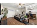 Cozy living room with wood floors, a modern sofa, an adjacent kitchen bar and stainless appliances at 6230 Gannetdale Dr, Lithia, FL 33547