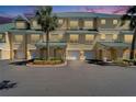 A yellow, three-story townhouse shows the entry and attached garages, under a green roof at 6451 Sunset Bay Cir, Apollo Beach, FL 33572