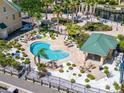 Community kidney-shaped pool surrounded by a manicured landscape and comfortable lounge chairs at 6451 Sunset Bay Cir, Apollo Beach, FL 33572
