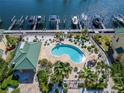 Community kidney-shaped pool surrounded by landscaping and boat slips in the adjacent waterway at 6451 Sunset Bay Cir, Apollo Beach, FL 33572