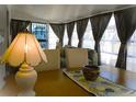 Sun room dining area featuring wood floors, stylish curtains, and an inviting space for meals and gatherings at 652 54Th S Ln # 153, Gulfport, FL 33707