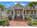 Charming front porch with white railings, brick walkway, potted plants, and tropical landscaping at 806 Narcissus Ave, Clearwater Beach, FL 33767