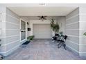 A welcoming entrance patio with seating, a ceiling fan, and front door that leads to an attached garage at 8244 Brentwood Rd, Seminole, FL 33777