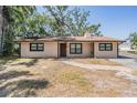 Charming one-story home features neutral siding, dark trim, and a brick walkway at 8816 Memorial Hwy, Tampa, FL 33615