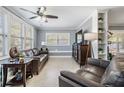 Cozy living room featuring neutral paint, windows with blinds, ceiling fan, and leather sofas at 8816 Memorial Hwy, Tampa, FL 33615