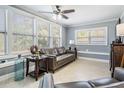 Comfortable living room with natural light, neutral paint, ceiling fan and leather sofas at 8816 Memorial Hwy, Tampa, FL 33615