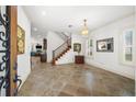 Bright foyer with tile flooring, staircase, chandelier, and views into the living spaces at 108 Bermuda Ave, Tampa, FL 33606