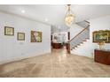 Spacious foyer with tile flooring, staircase, chandelier, and views of the kitchen at 108 Bermuda Ave, Tampa, FL 33606