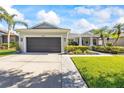 Beautiful home with a well-kept lawn, mature palm trees, and a spacious driveway leading to a two-car garage at 10922 Holly Cone Dr, Riverview, FL 33569