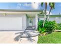Close-up of the front entrance featuring a brick facade, manicured landscaping and freshly painted door at 11035 Huron Rd, St Petersburg, FL 33708
