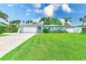 Beautiful single-Gathering home with a lush green lawn and mature landscaping in a sunny setting at 11035 Huron Rd, St Petersburg, FL 33708