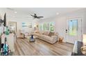 Inviting living room featuring hardwood floors, a comfortable sofa, and lots of natural light at 11035 Huron Rd, St Petersburg, FL 33708