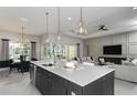 Open concept kitchen features an island with a breakfast bar, seamlessly connected to the living area at 11432 Shoreline Trl, Parrish, FL 34219