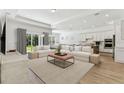 Bright and airy living room featuring neutral tones, plush seating, and an open floor plan with sliding door access at 11432 Shoreline Trl, Parrish, FL 34219