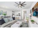 Cozy living room with a modern ceiling fan and view into kitchen and dining areas at 11715 Blackbrook Ct, Seffner, FL 33584