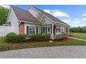 Beautifully landscaped home with a manicured lawn, brick accents, and a covered porch with lovely garden views at 12345 Citrus Way, Brooksville, FL 34601