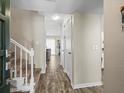 Inviting foyer with hardwood floors, staircase, coat closet and a view into the living room at 1303 N Mcmullen Booth Rd # 1303, Clearwater, FL 33759