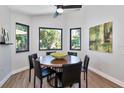 Bright dining room with modern light fixture and three windows overlooking the landscaped backyard at 1310 Country Trails Dr, Safety Harbor, FL 34695
