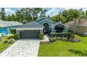 Charming home with a gray roof, manicured lawn, and beautiful landscaping at 1310 Country Trails Dr, Safety Harbor, FL 34695