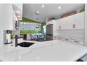 Bright, stylish kitchen featuring white cabinetry, sleek countertops, and stainless steel appliances at 1310 Country Trails Dr, Safety Harbor, FL 34695