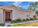 Inviting single Gathering home featuring a solid wood front door and tropical landscaping at 1505 Trailwater St, Ruskin, FL 33570
