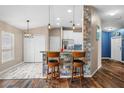 Open-concept kitchen featuring a breakfast bar with pendant lighting and views into an adjoining dining room at 1505 Trailwater St, Ruskin, FL 33570