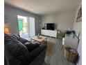 Bright living room showcasing modern decor, a comfortable sofa, and balcony access at 1799 N Highland Ave # 32, Clearwater, FL 33755
